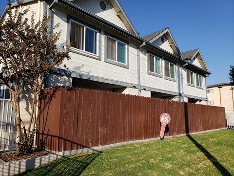 A brown fence with a red sign that says "BEEP" on it.