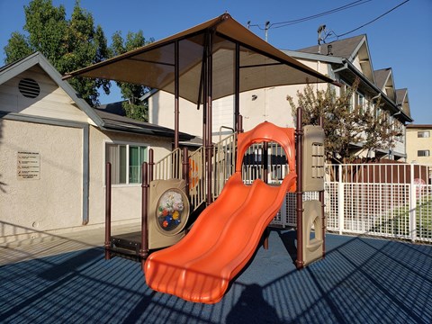 A playground with a slide and a climbing frame.