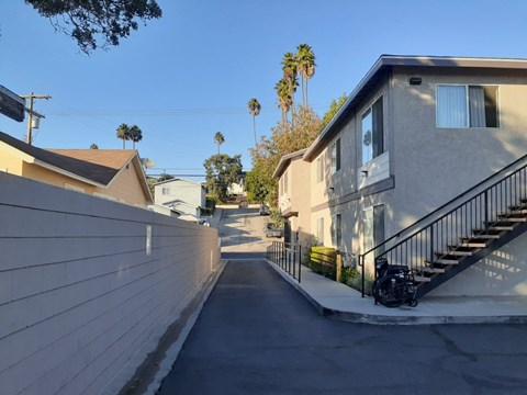 A residential street with houses on both sides and a clear blue sky.