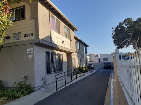 A street view of a residential area with houses on both sides and a car parked on the street.