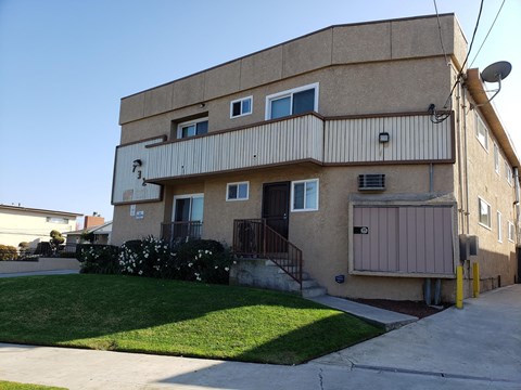A beige apartment building with a satellite dish on the roof.