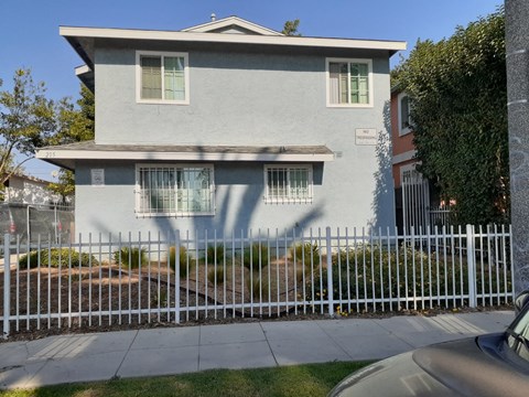 A house with a white fence in front of it.