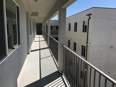 a corridor in an office building with shadows on the ground