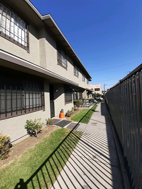 A sunny day at a residential area with apartment buildings and a sidewalk.