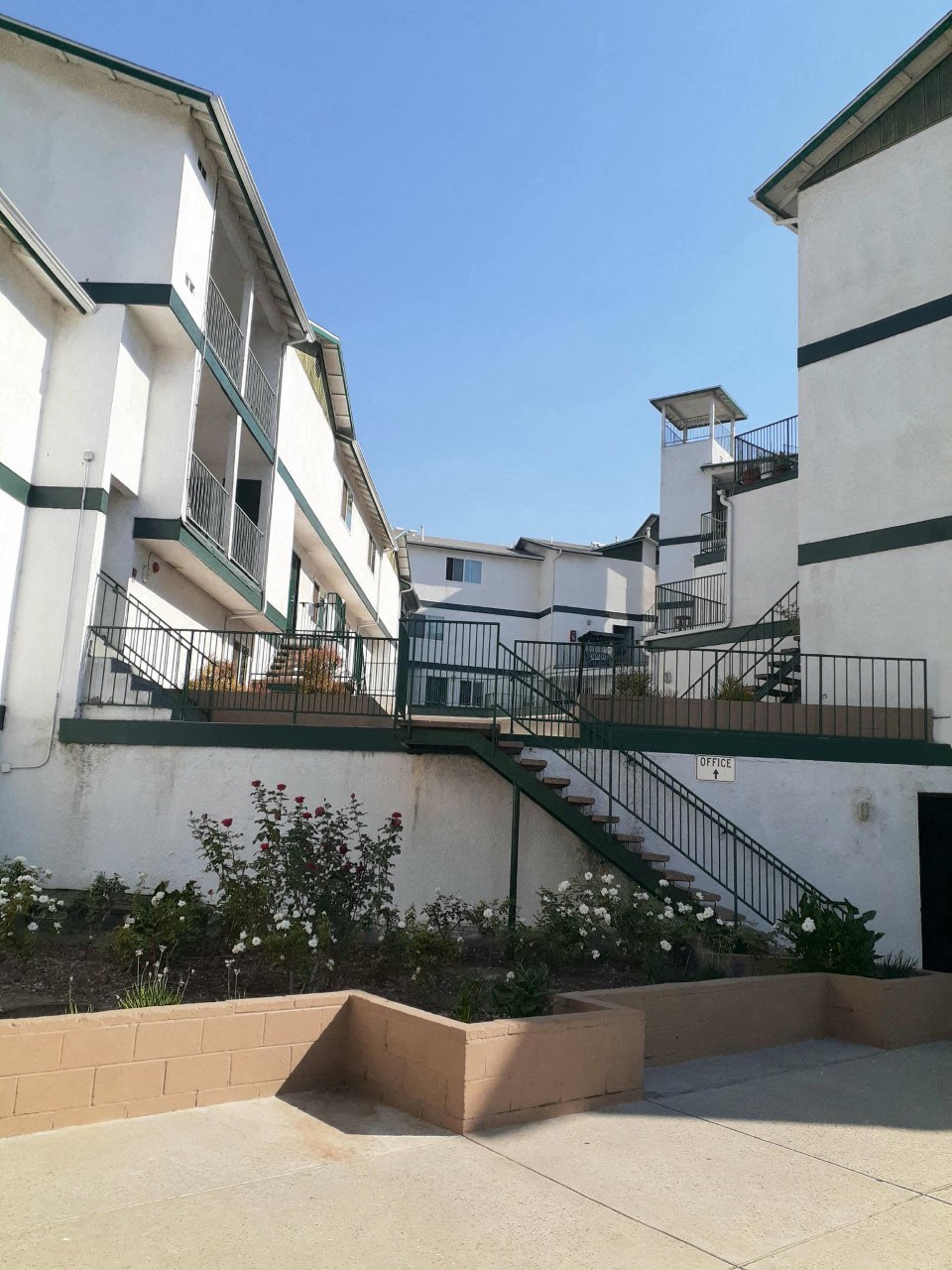 an apartment building with stairs and balconies and a blue sky