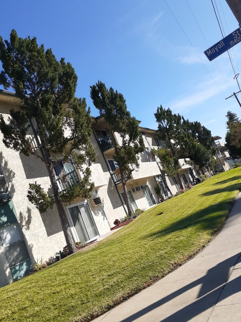 the view of an apartment building from the sidewalk