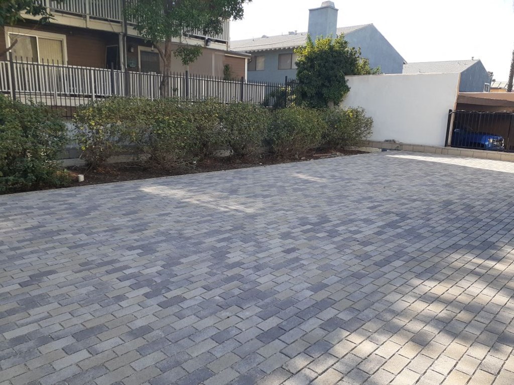 a brick driveway with a house in the background