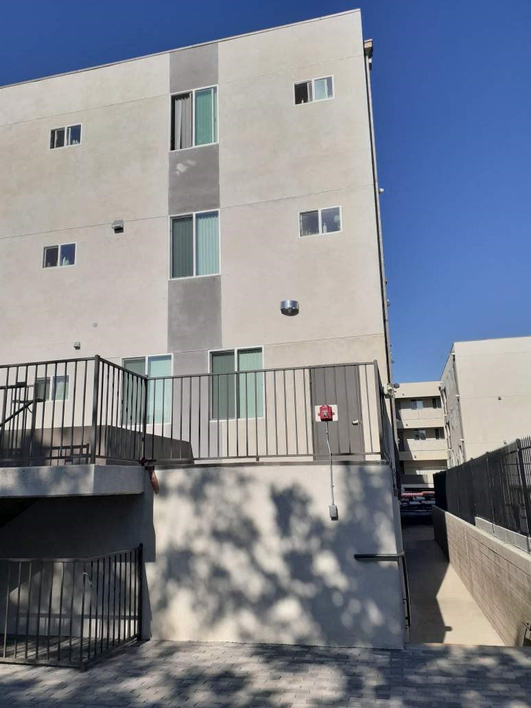 the side of an apartment building with stairs and a balcony
