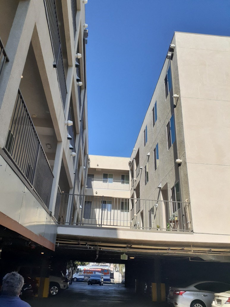 a parking garage under a bridge between two buildings