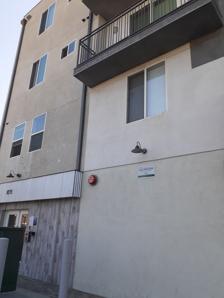 the outside of a building with a balcony and a sign on the side of it