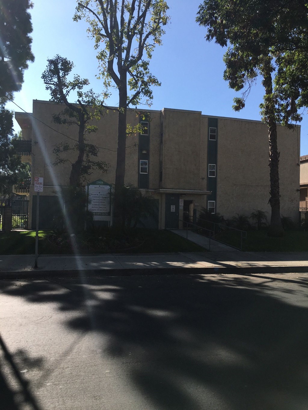 a building on the side of a street with trees