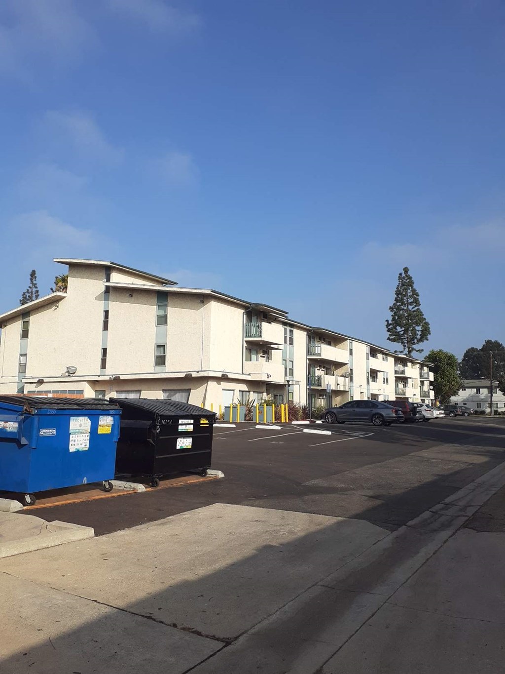a building with dumpsters in front of it in a parking lot