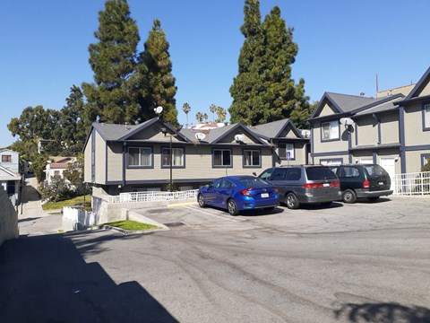 A blue car is parked in front of a grey building.