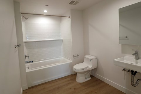 A white bathroom with a toilet, sink, and bathtub.