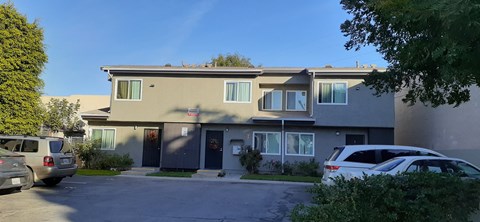 A two-story building with a parking lot in front.