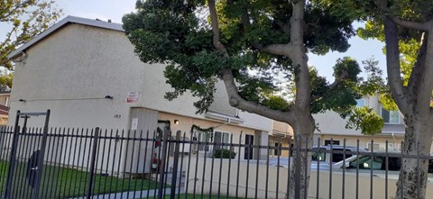A white building with a black fence in front of it.