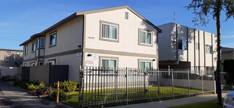 A white house with a black fence in front of it.