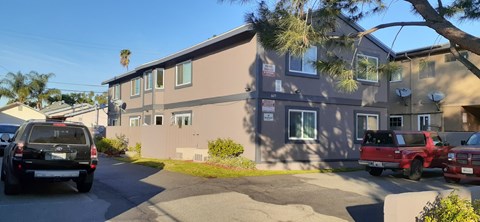 A two-story building with a parking lot in front.