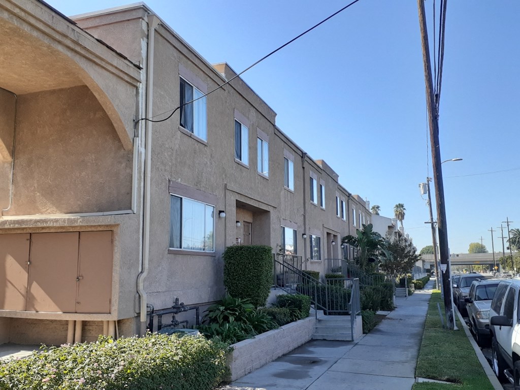 an apartment building with a sidewalk in front of it