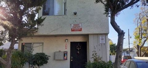 A white building with a red and white sign on the front.