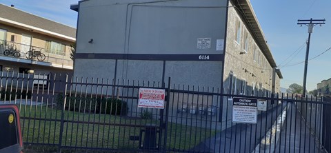 A black fence with a red and white sign on it.
