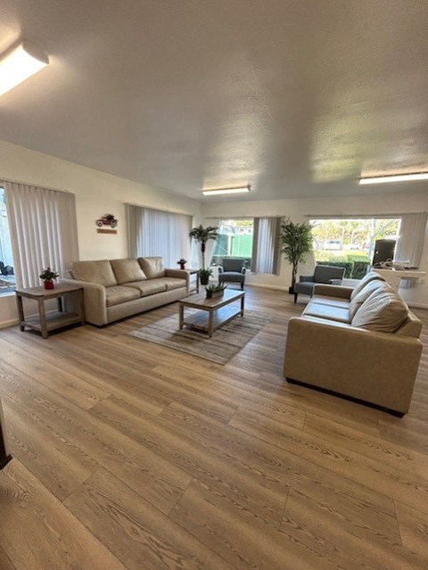 A spacious living room with wooden floors and furniture.