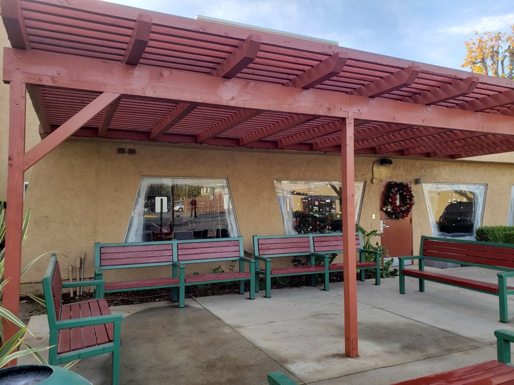 a patio with benches and a pink roof