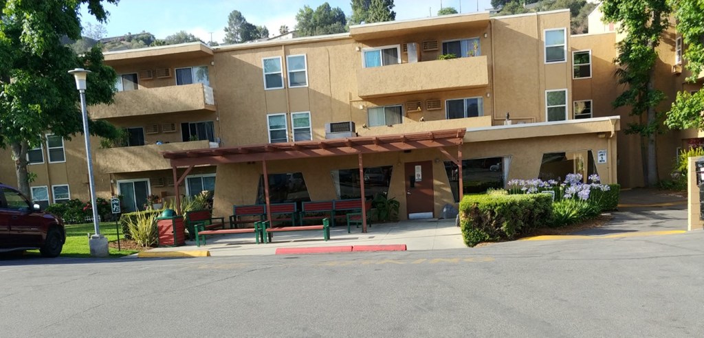 a building with a porch and benches in front of it
