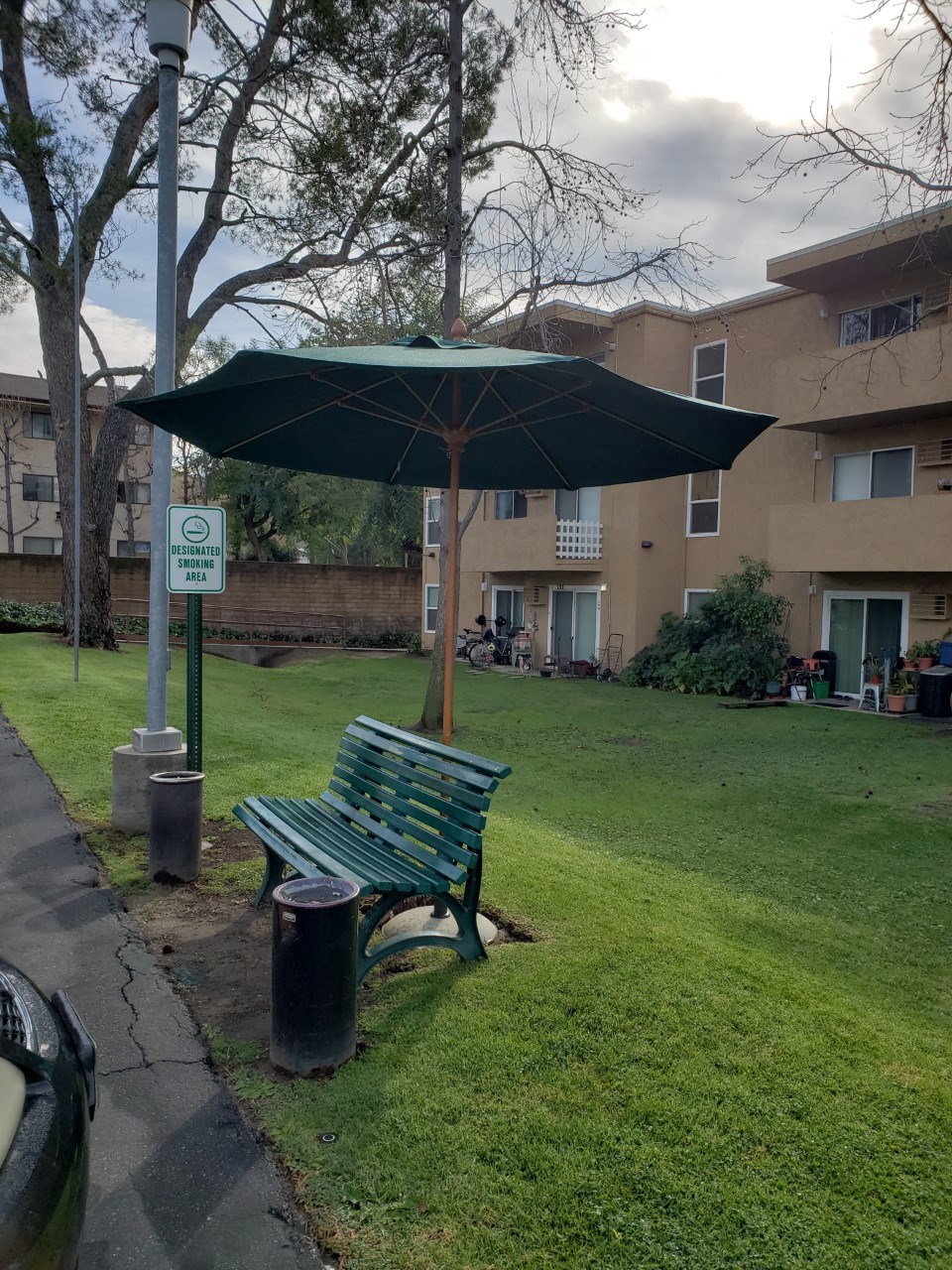 a park bench with an umbrella in the grass