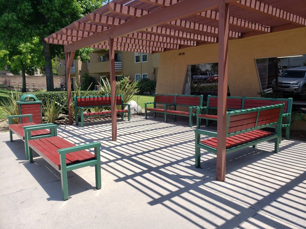 a group of benches sitting under a wooden pavilion