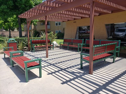 a group of benches sitting under a wooden pavilion