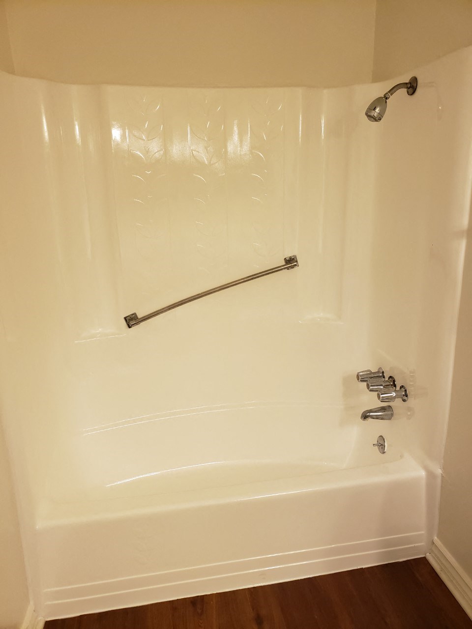 a white tub with a shower in a bathroom