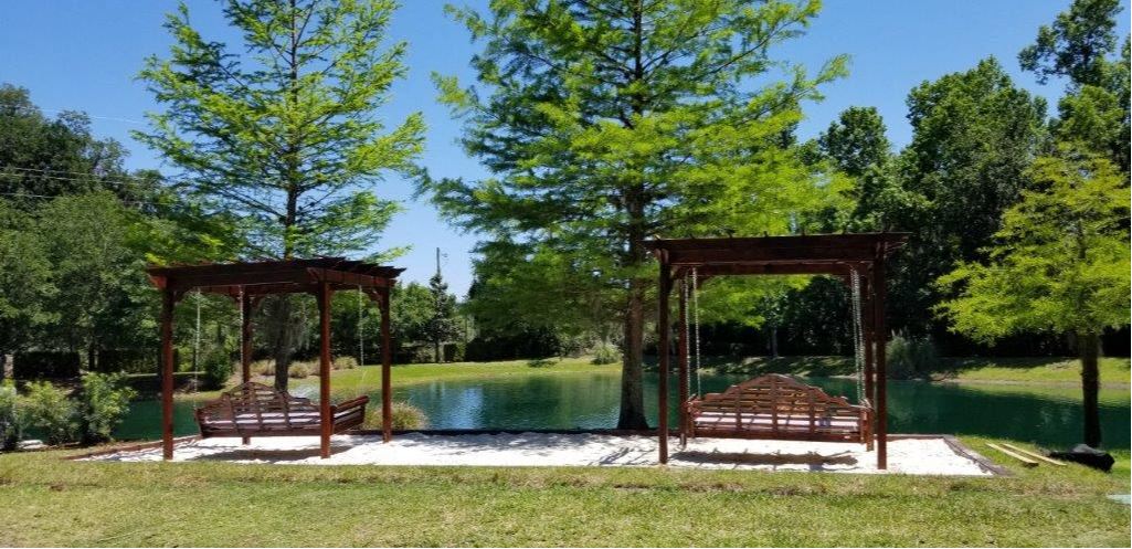 2 Pergola swing beds located on top of sand box located near the pond at The Bartram Apartments in Gainesville, FL 32608