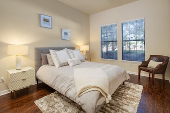 Bedroom pictured with full size bed, 2 night stands and accent chair in the far right corner. - Photo Gallery 34
