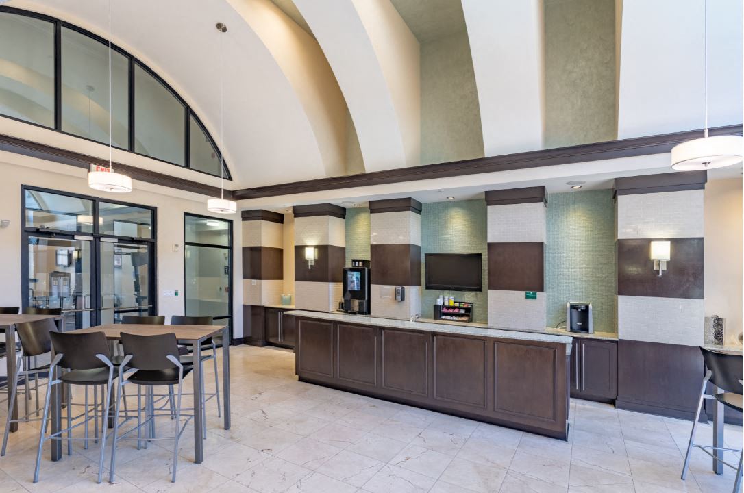 Clubhouse Cafe with seating area. Starbucks coffee machine and self serve coffee bar available 24/7 at The Bartram Apartments in Gainesville, FL 32608
