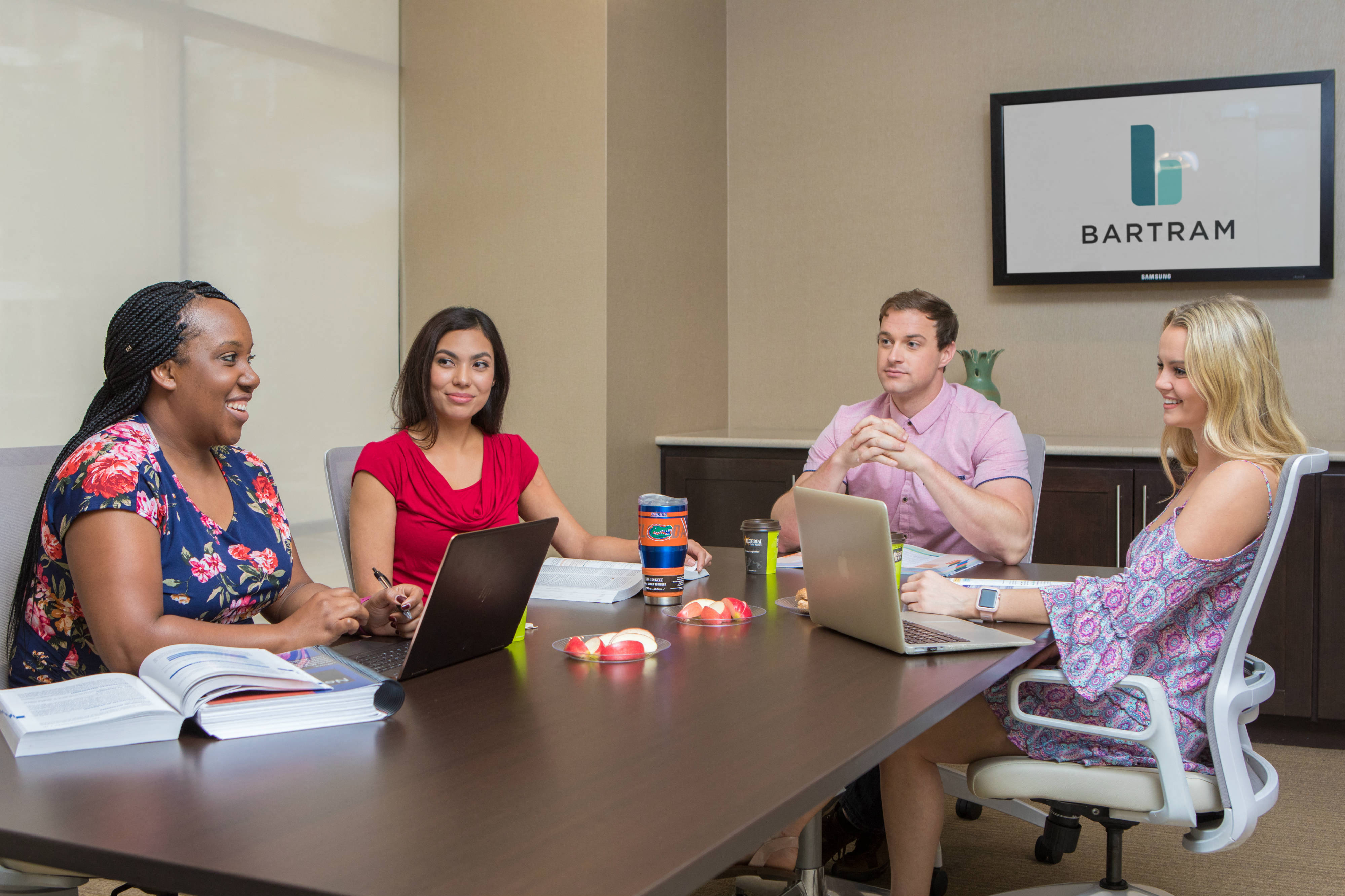 Business center with people sitting at the conference table at The Bartram Apartments in Gainesville, FL 32608