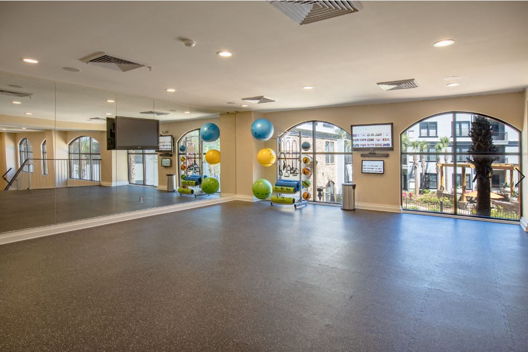 2nd floor of Fitness Center with wall to wall mirror and WellBeats virtual trainer. Exercise balls and yoga mats available at The Bartram Apartments in Gainesville, FL 32608