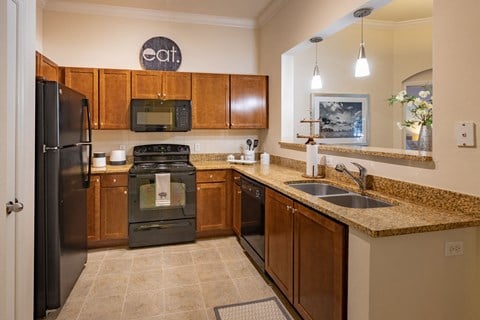 U shaped kitchen with black appliances at The Bartram, Gainesville, Florida.