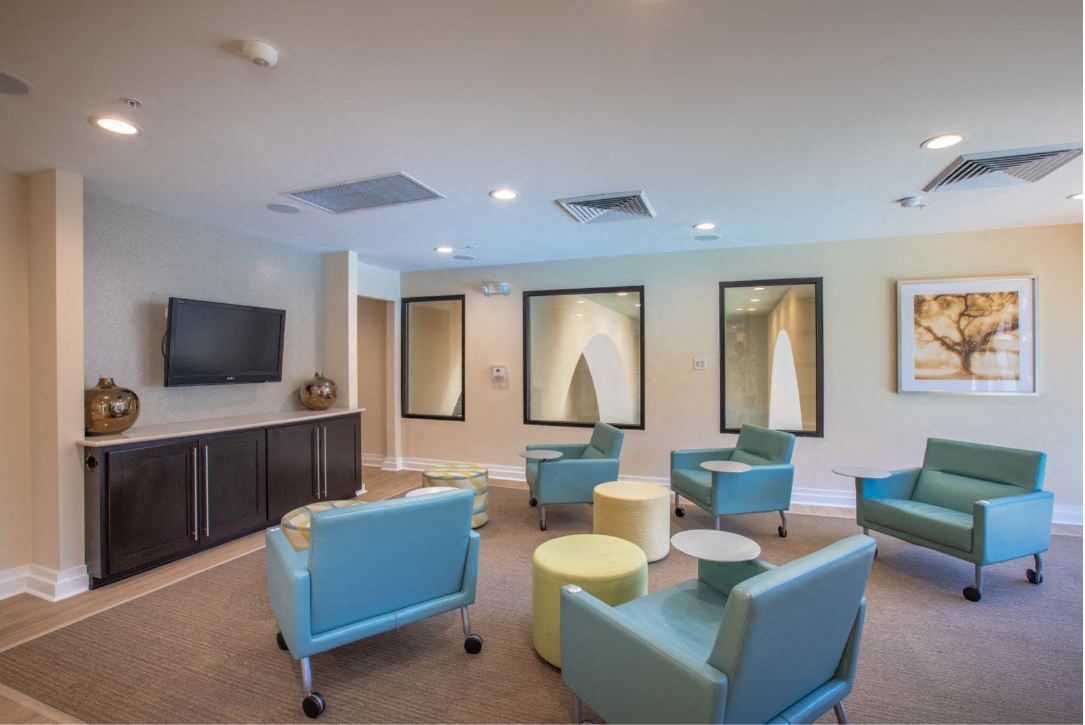 5 rolling desk chairs seating area facing TV located in the 2nd story of the Clubhouse at The Bartram Apartments in Gainesville, FL 32608