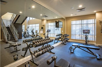 Weight room with benches and peloton bicycle. - Photo Gallery 25
