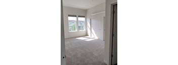 a bedroom with two windows and a door