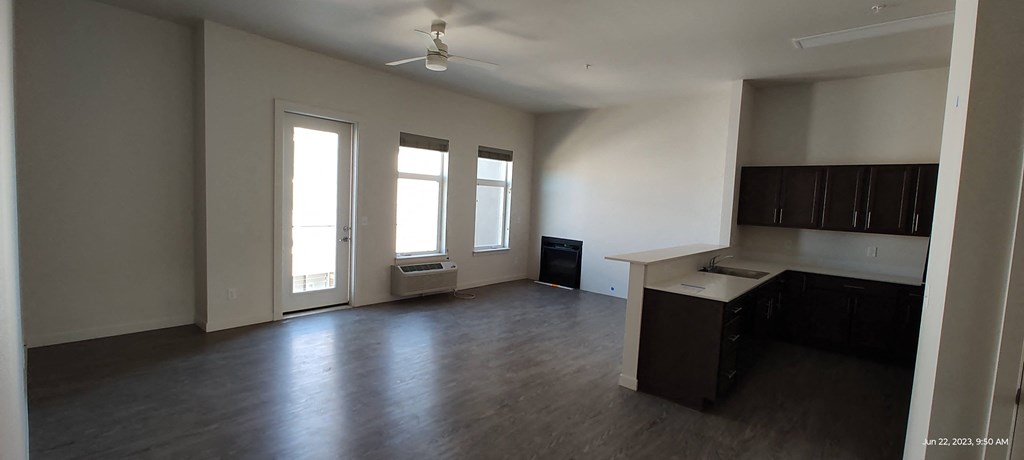 an empty living room with a kitchen