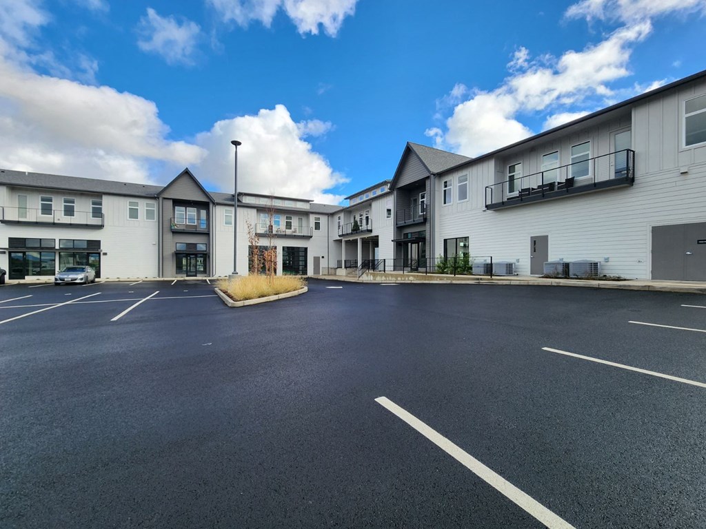 an empty parking lot in front of apartment buildings