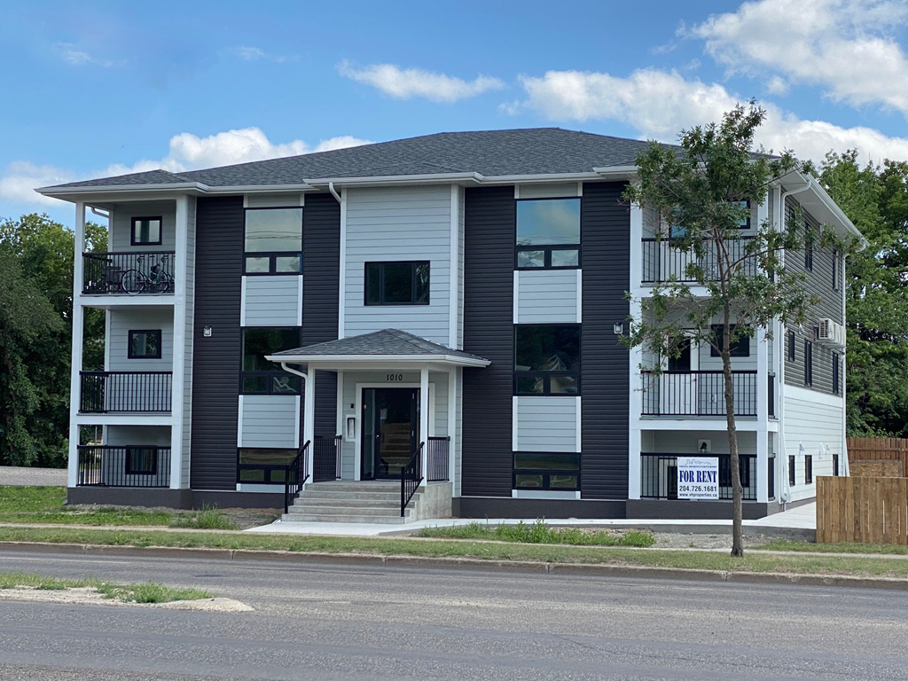 a white and black apartment building on the corner of a street