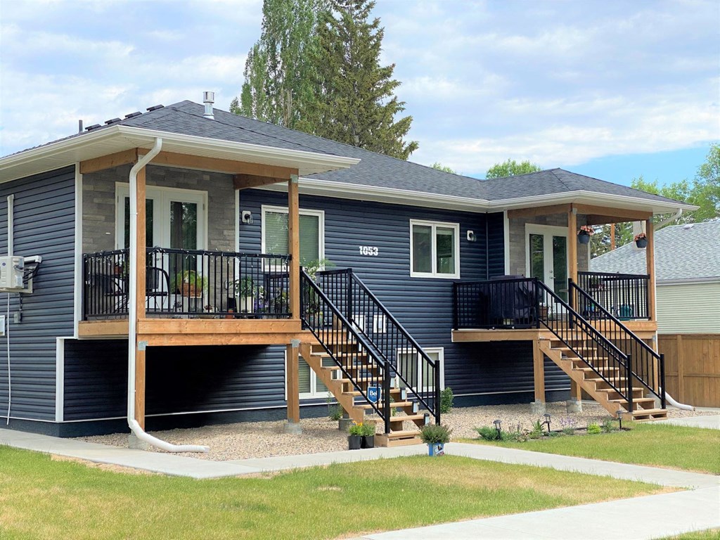 a blue house with a deck and a porch