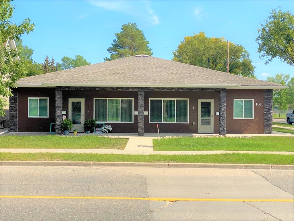 a brown brick house with a street in front of it