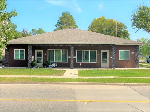 a brown brick house with a street in front of it