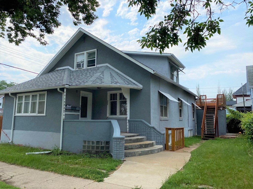 a blue house with stairs and a sidewalk