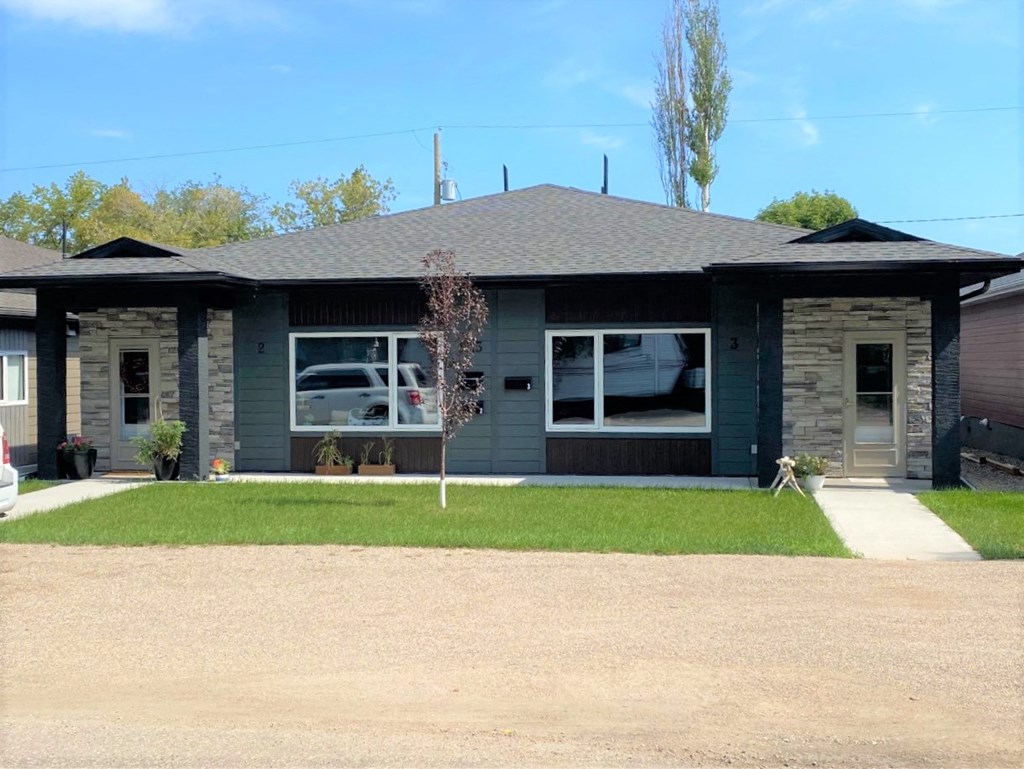 a blue house with a lawn in front of it