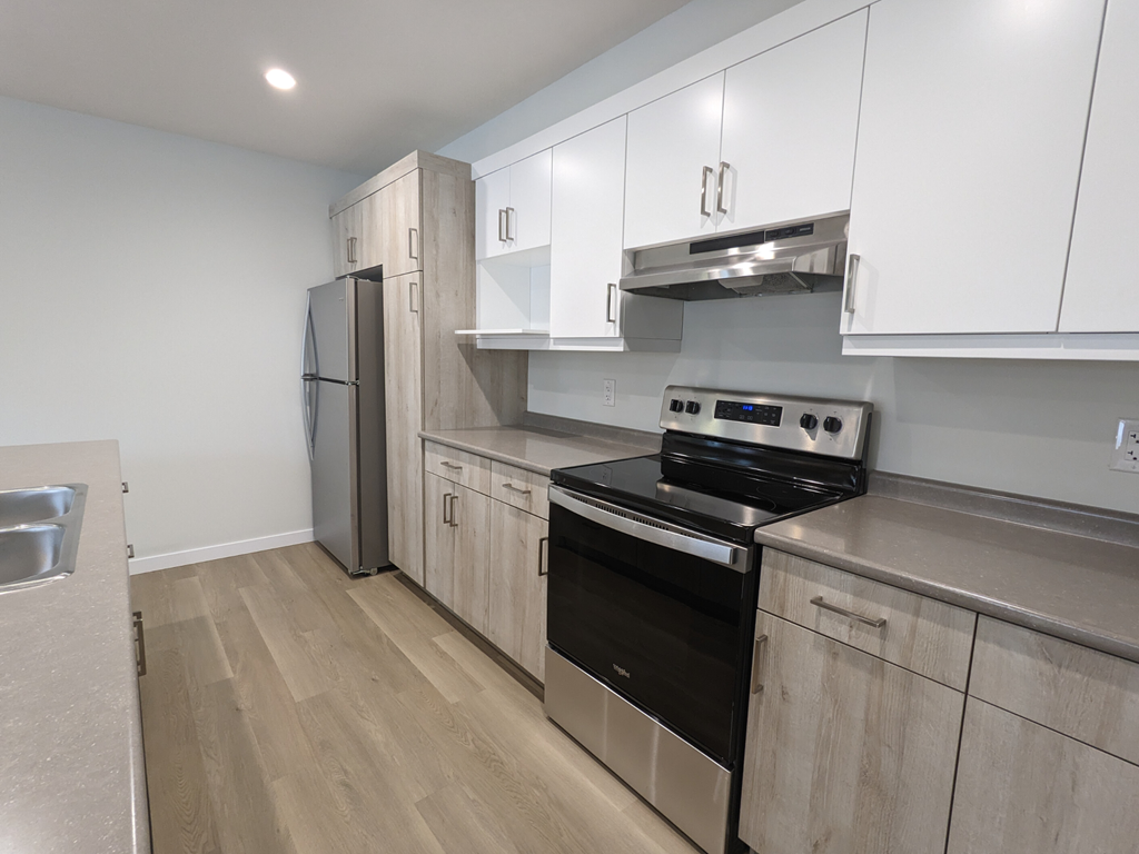 a kitchen with white cabinets and stainless steel appliances